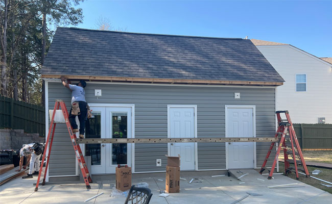 Siding being installed on a poolhouse