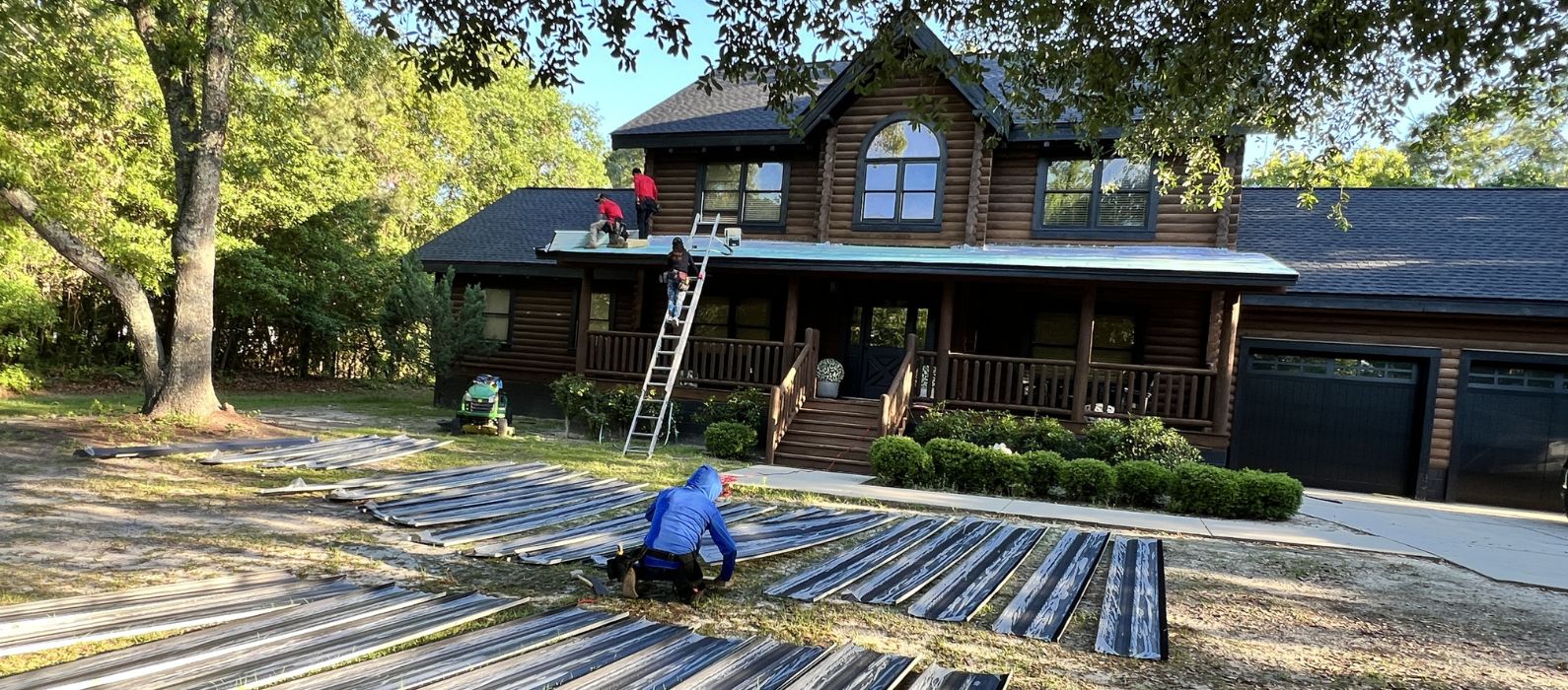 Crew installing Metal roofing materials on a log cabin home.