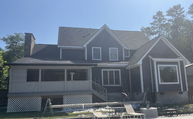 Same home after new vinyl siding installation in a dark finish.