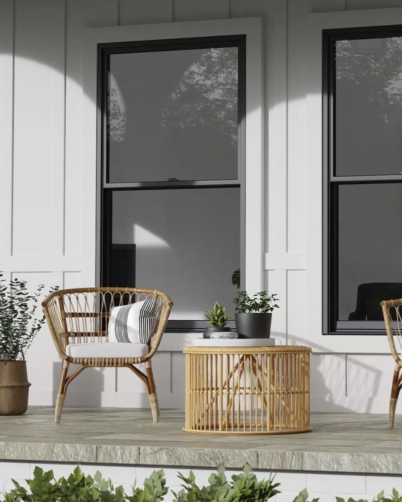 Bricked home's front porch with arched walkway leading to Red front door with a basket wreath on the doors glass.