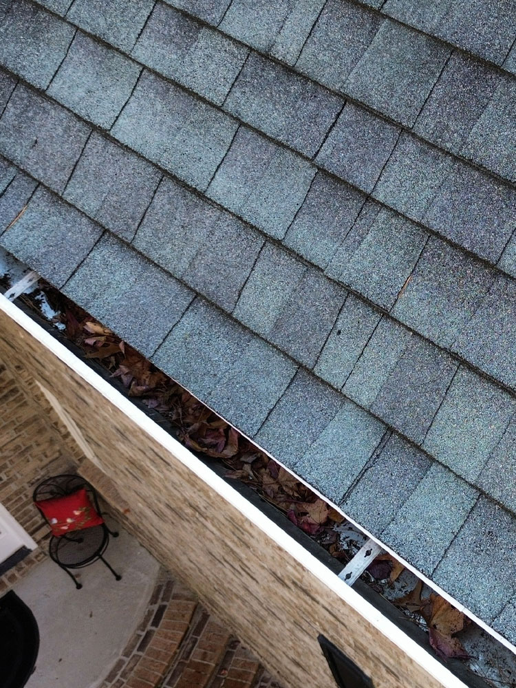 Crew installing new roofing and underlayment on a large home.